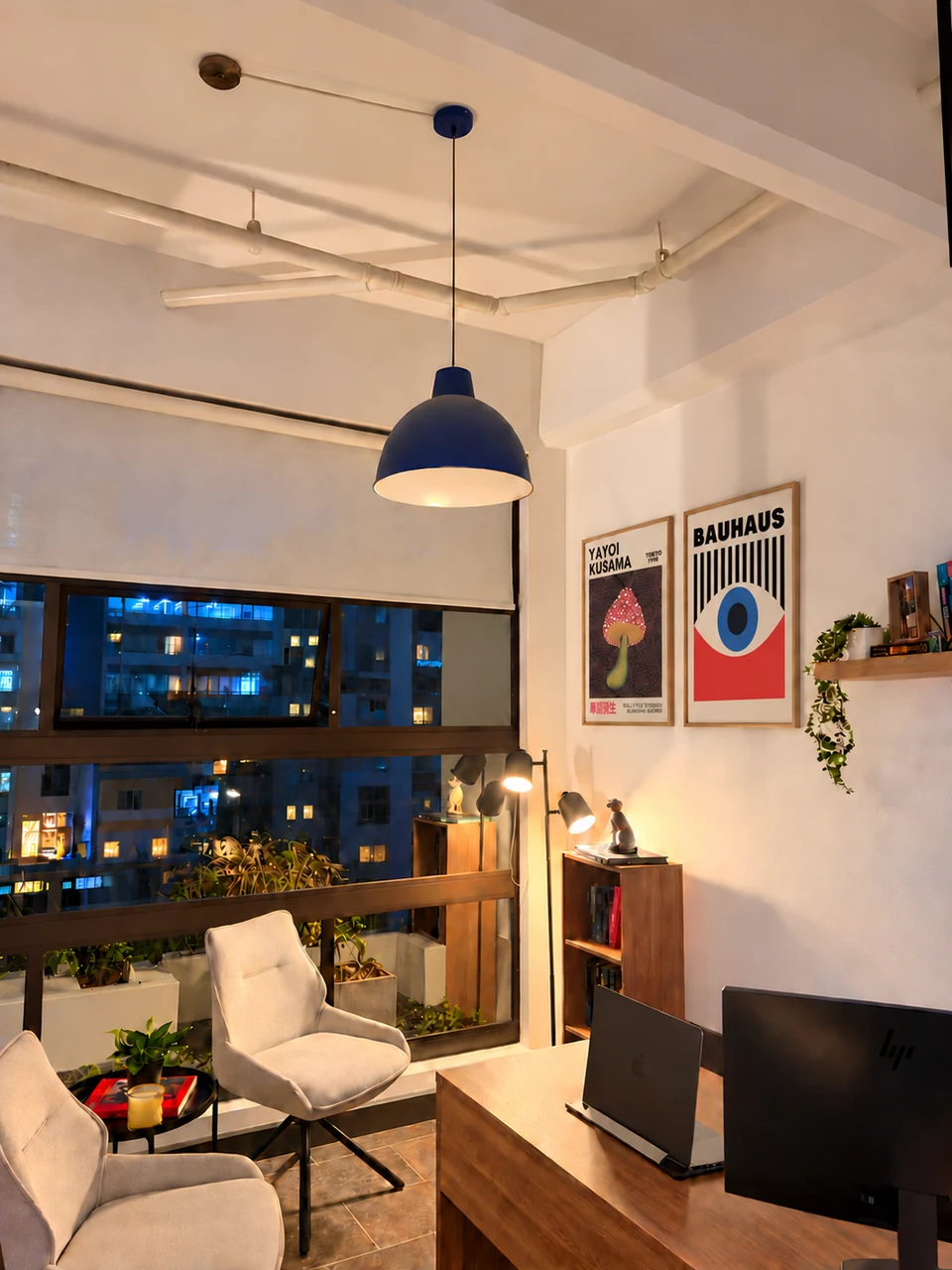 Espacio de conversación con butacas junto a un escritorio y una ventana